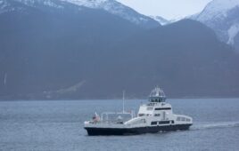 boat-on-water-mountains-in-background